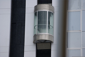 Aufzugsmodernisierung mit LiftPLAN360: Eine Aufzugskabine an der Außenfassade eines Gebäudes.